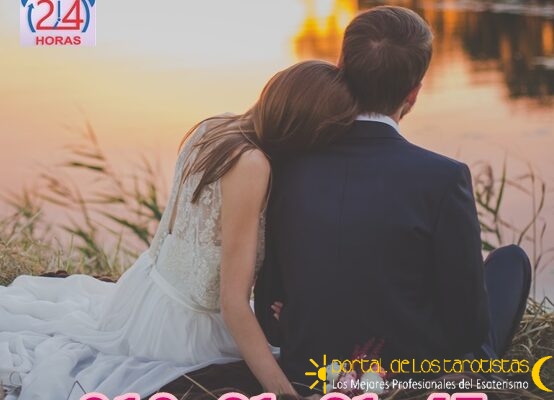 wedding-couple-sitting-on-green-grass-in-front-of-body-of-70737